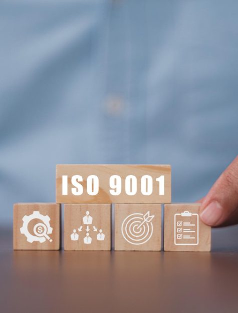 businessman-pressing-his-finger-wooden-cubes-with-abbreviation-iso-9001-iso-quality-control-certification-concept